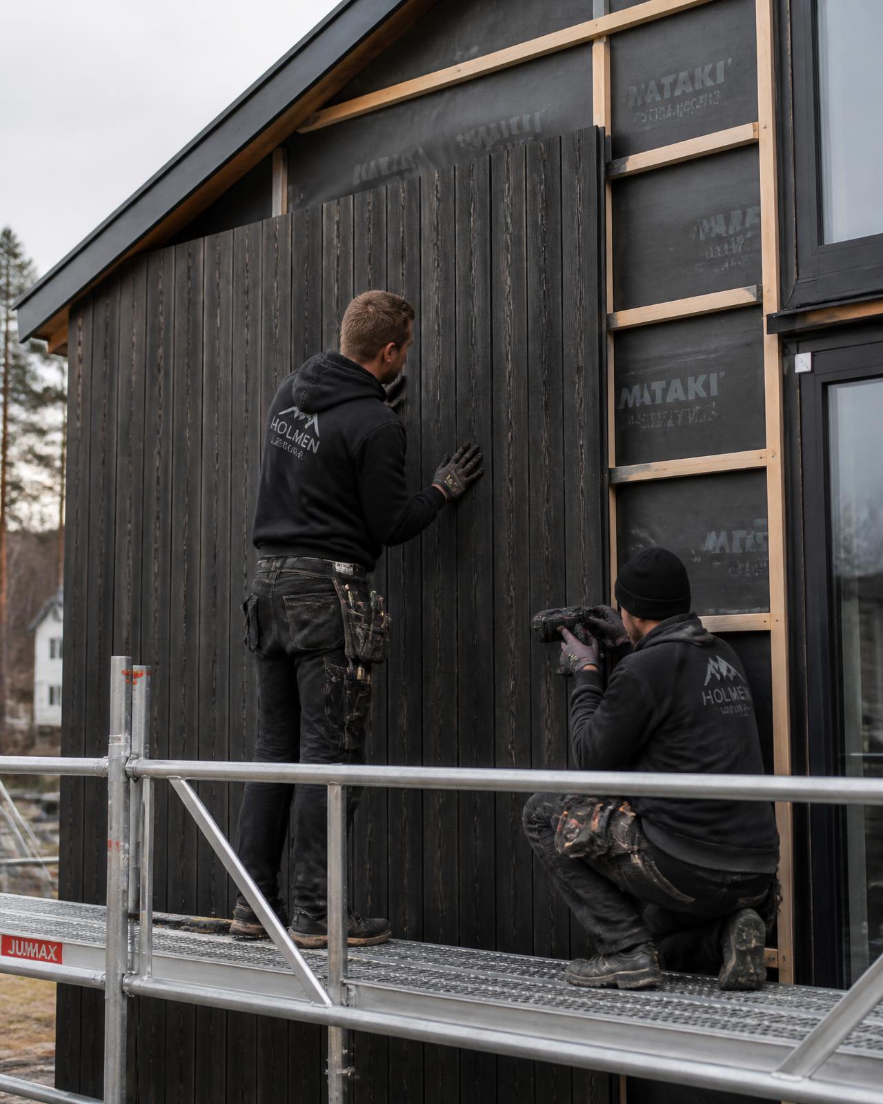 Tømrere monterer ny trekledning på fasade